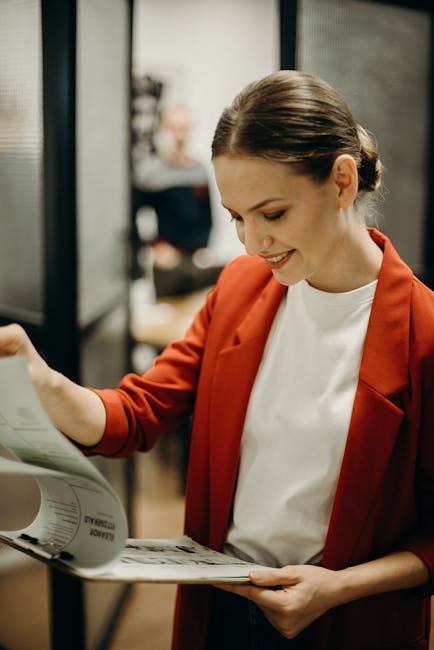 Confident businesswoman reading documents in the office with a smile.